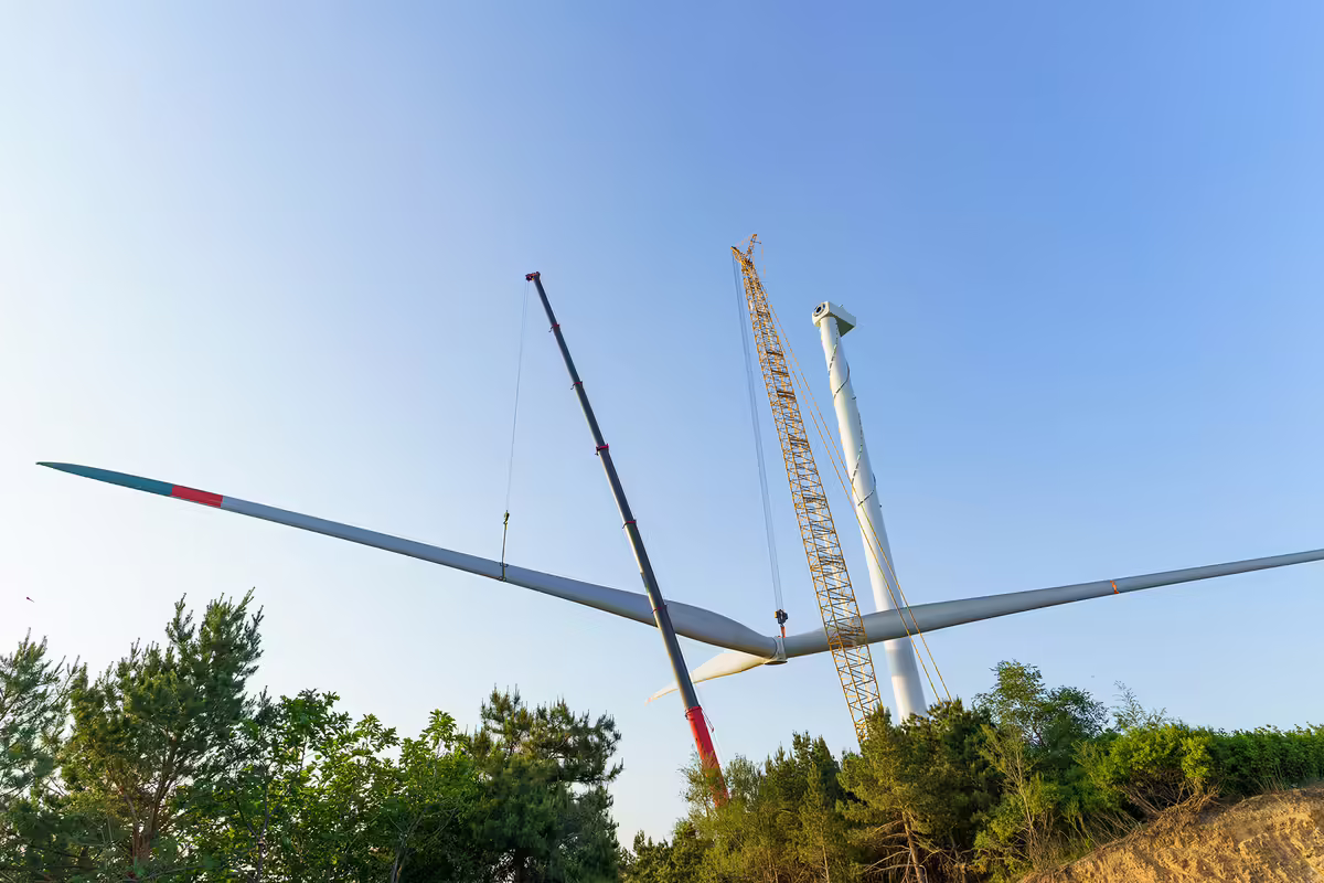 A wind turbine blade being lowered to the ground