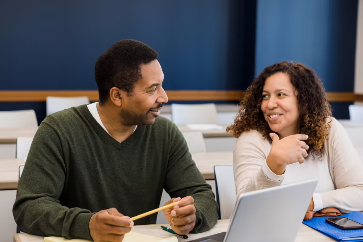 man and woman talk together in a meeting room