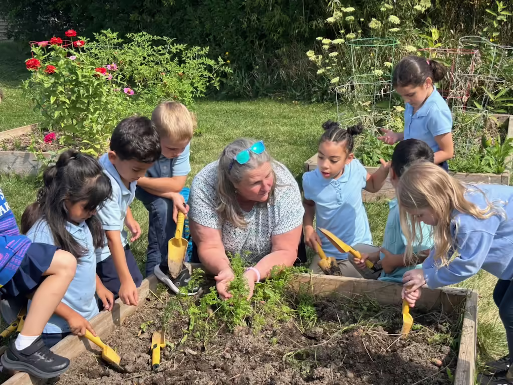 Extension staff member gardening with youth