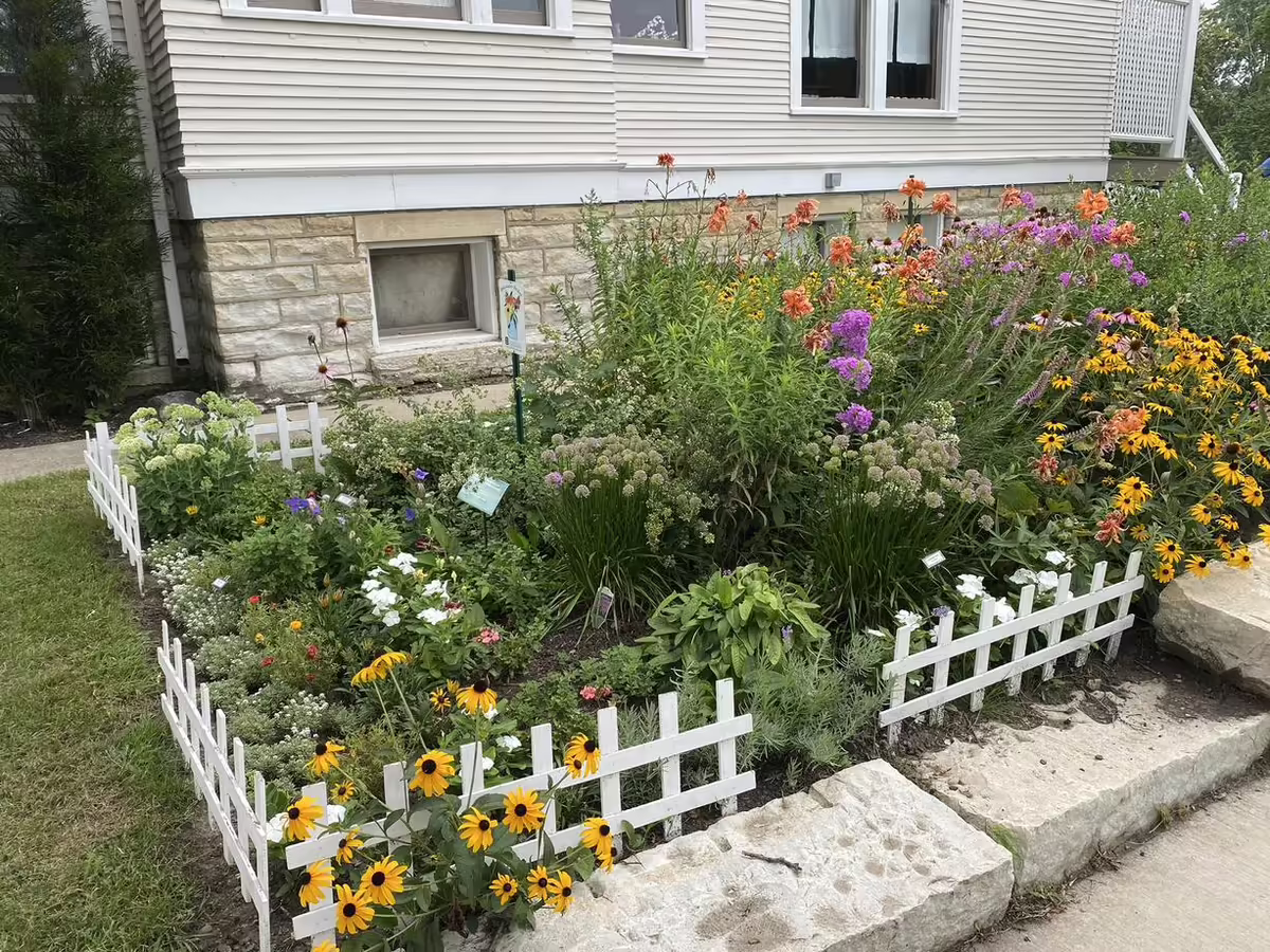 a garden bed sits next to stones built as a retaining wall