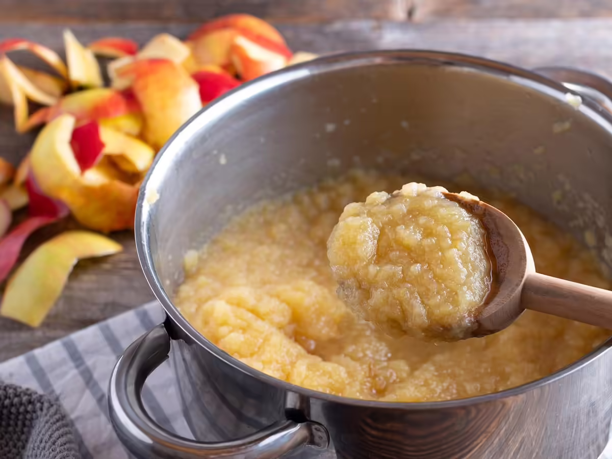 peeled apples being cooked down in pan to make applesauce