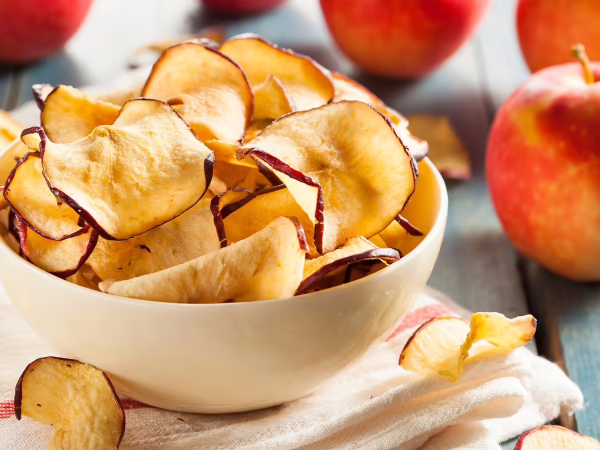 dried red apple slices in white bowl