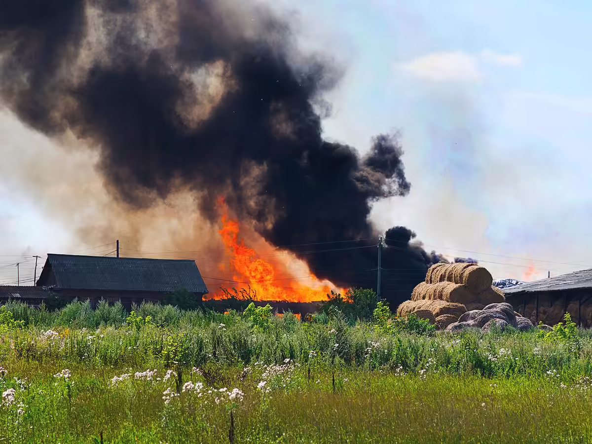 farm fire with buildings and hay