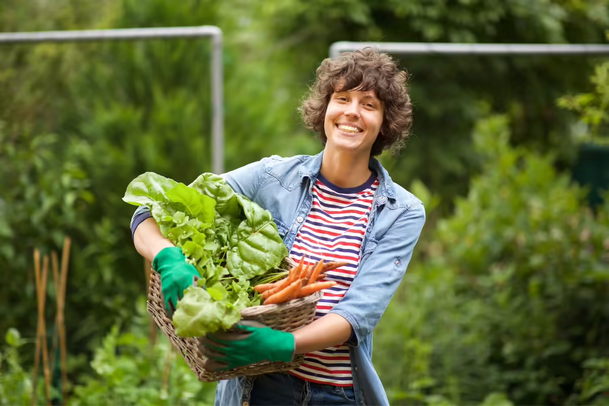 farmer poses with a box of vegetables