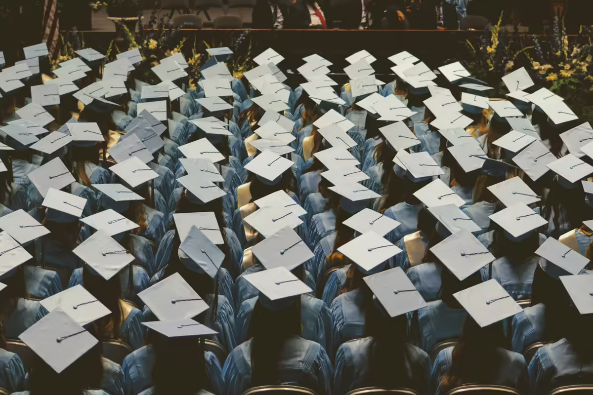 people sitting down with graduation caps on