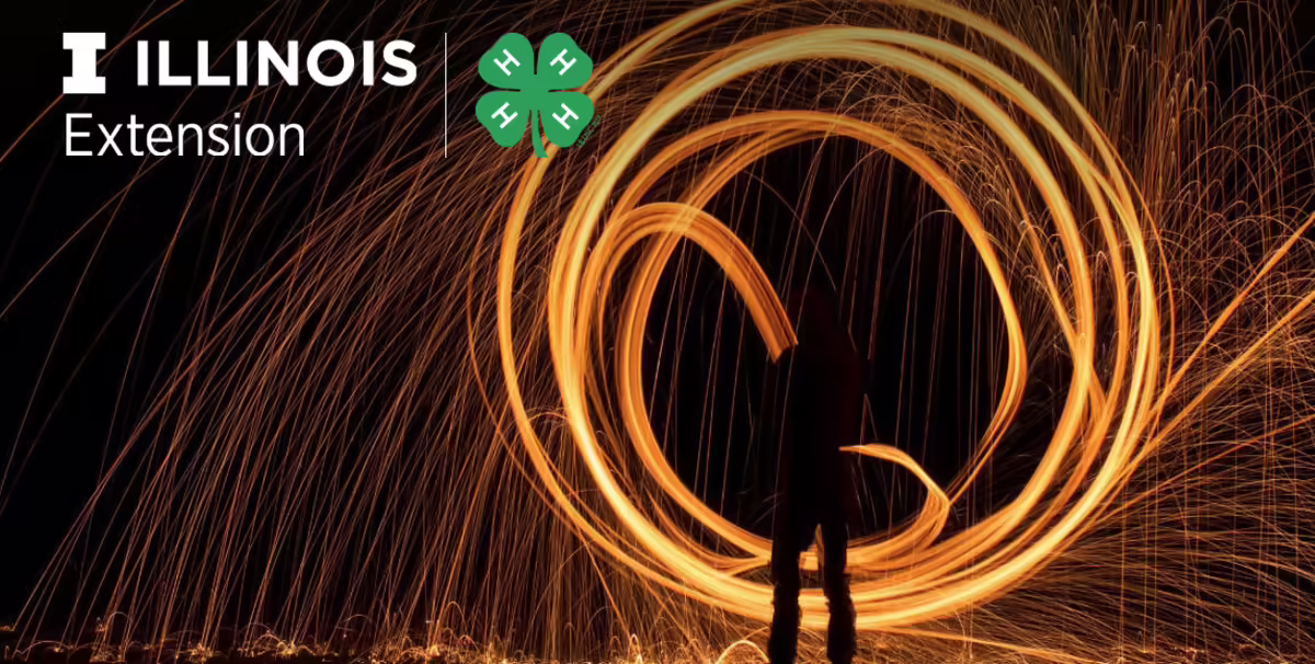 dark background with person swirling a sparkler in circles