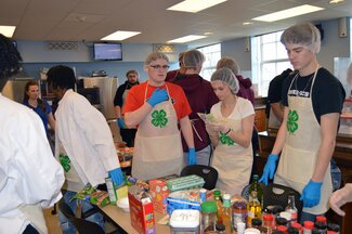 Students standing around the ingredients at the 4-H Regional Cooking Challenge