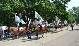 People with flags on horses.