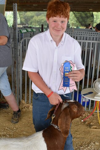 boy in white with ribbons and goat