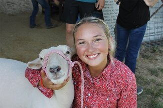girl in red shirt with white sheep 