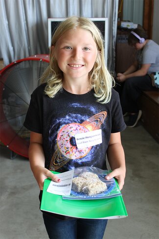girl in black graphic shirt holding baked goods
