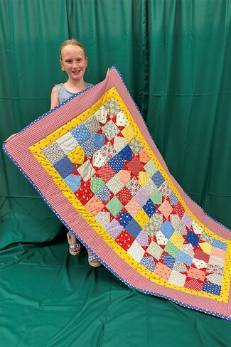 girl holding a colorful quilt