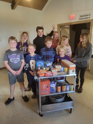 group of kids around donations collected for community service project