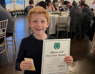boy holding up certificate