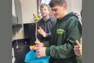 Students test their newly created boats made from legos