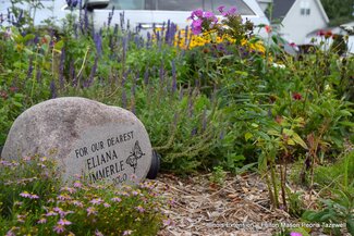 memorial rock in a flower garden