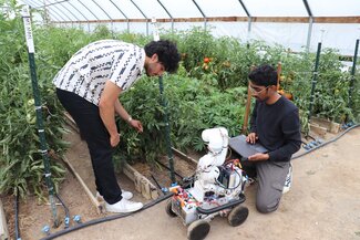 students and robot in the high tunnels