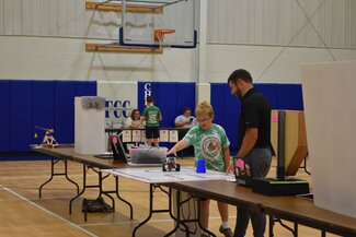 Young boy demonstrating his Robotics project