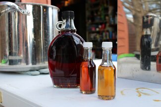 Three different colored bottles of maple syrup