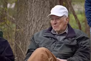 Bob Coppernol sitting with leg crossed out in the woods