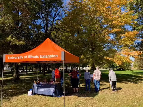 People under a tent outside talking to others