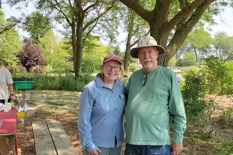 Two people smiling in a garden
