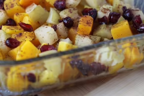 spiced, cubed apple, winter squash, and cranberries in a glass baking dish