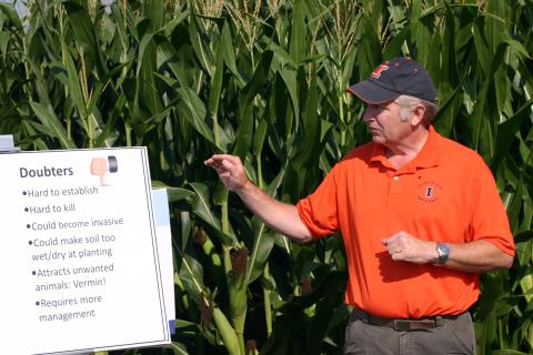 Dennis Bowman demonstrating at University of Illinois Agronomy Day at edge of cornfield