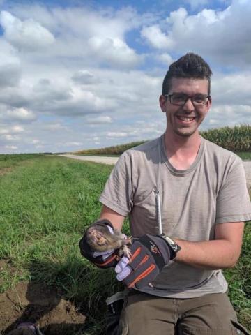 Researcher in the field holding gopher