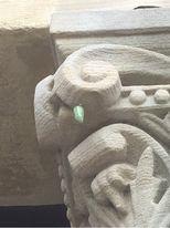 Monarch chrysalis clinging to carved limestone building column