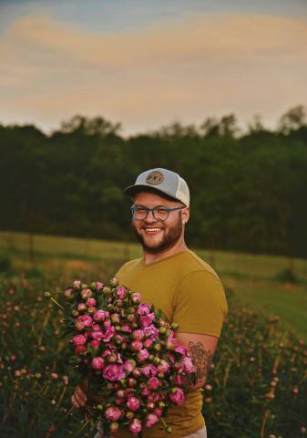 Drew Groezinger holds some of the flowers he grows at his farm