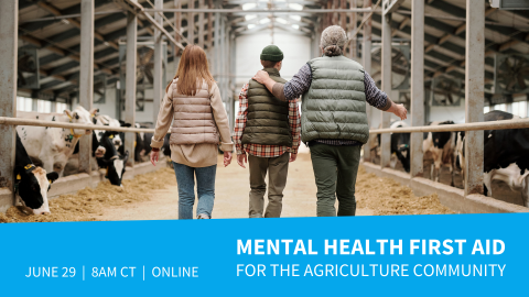 three people walking down the middle of a cattle barn