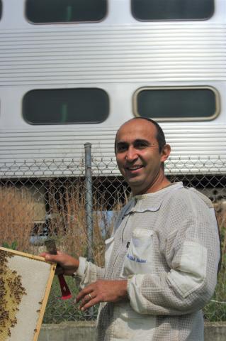 ""Oscar Villa, urban beekeeper with Metra train in background