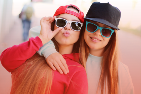 two teens with sunglasses smiling