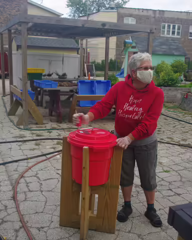 Mary demonstrating the salad spinner in its custom built stand 