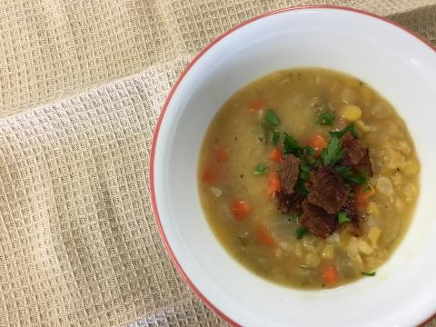 Yellow split pea soup topped with bacon and parsley