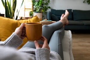 person sitting on couch with cup of coffee