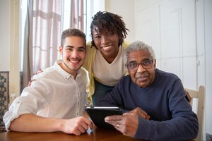 three people smiling while looking at tablet