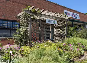 garden arbor in front of a brick building