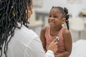 young black girl being treated by black doctor