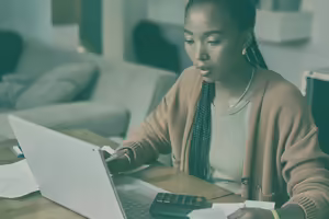woman in cardigan using a laptop