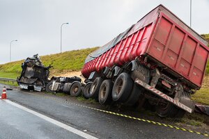 overturned grain truck on side of highway