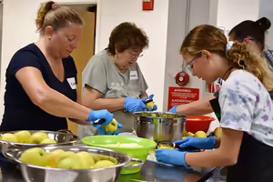 Class participants peeling and cutting apples