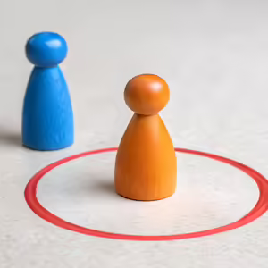 blue and orange game pawns with circle drawn around orange one