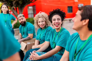 Group of adults wearing matching shirts sitting down and smiling 