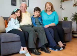 Grandparents and grandchildren on a couch smiling