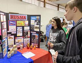 Teen boy and girl look at display about Russia