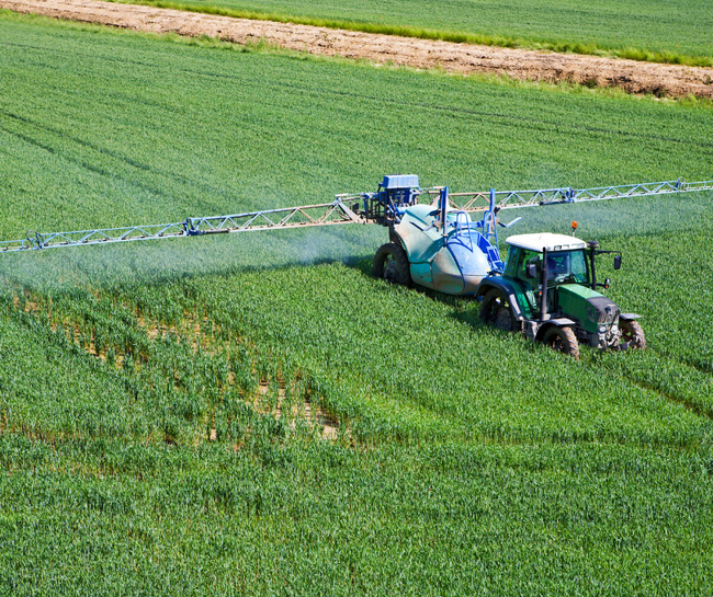 farmer applying pesticide to field
