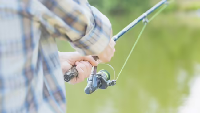 Back view of someone fishing with a fishing pole
