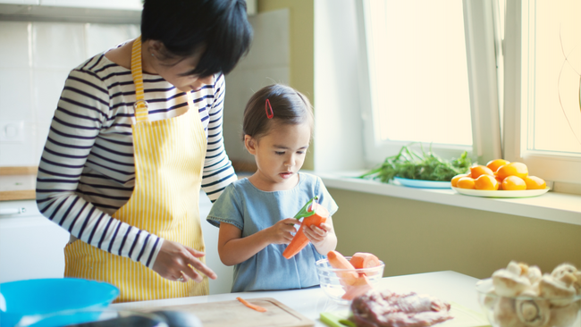An adult teaching a child how to cook